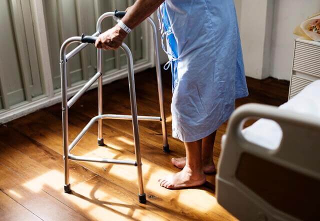 elderly person using a walking frame health and safety in care homes